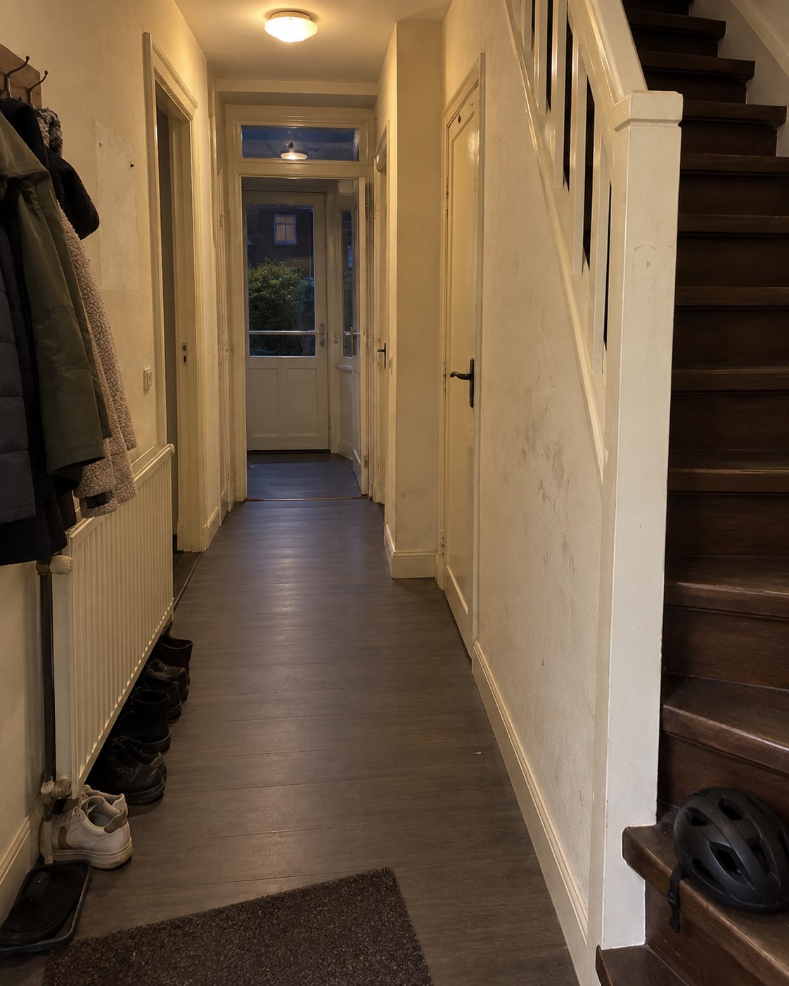 Situatie vooraf: een donkere hal met trap, vergeelde wanden en vlekken